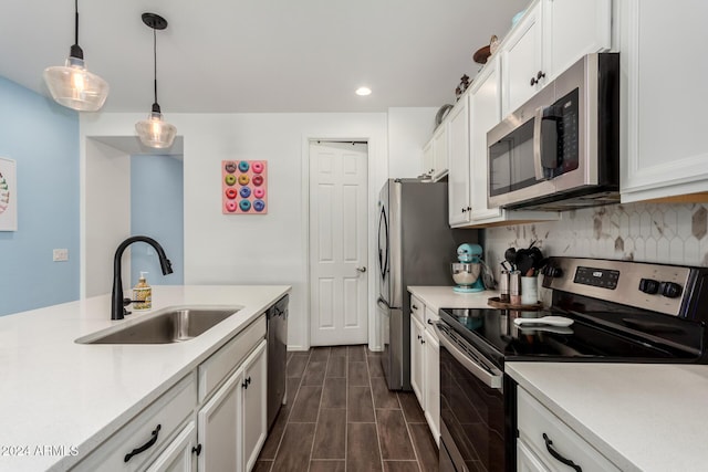 kitchen with white cabinets, decorative light fixtures, sink, and stainless steel appliances