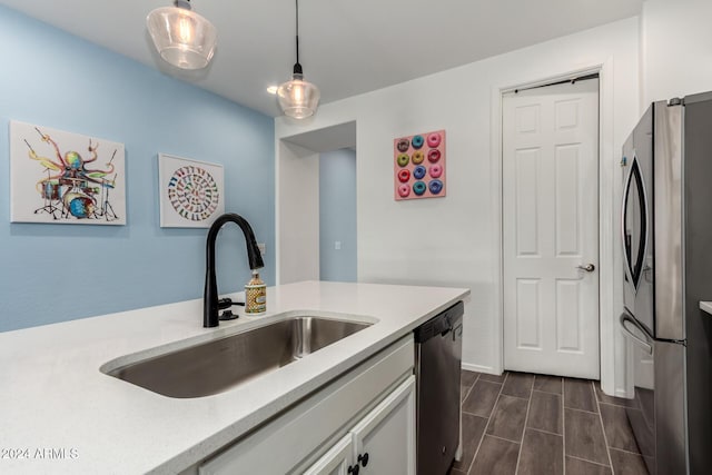 kitchen featuring sink, white cabinets, pendant lighting, and appliances with stainless steel finishes