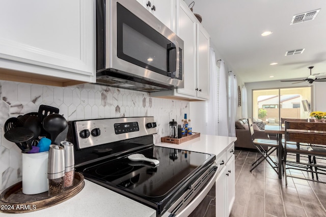 kitchen featuring backsplash, white cabinets, ceiling fan, appliances with stainless steel finishes, and light hardwood / wood-style floors