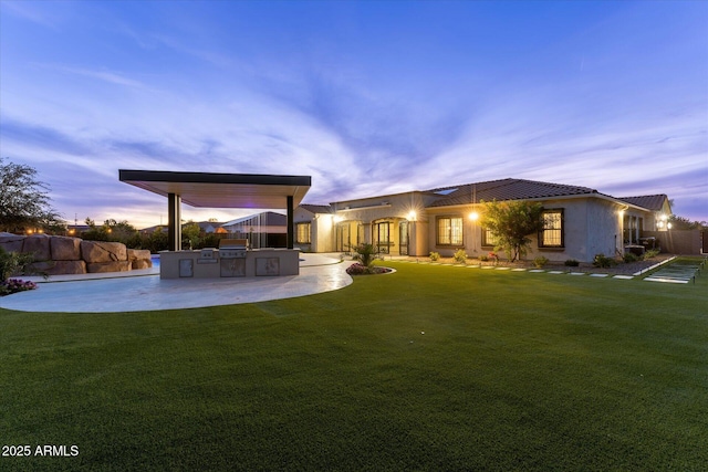 4547 S Banning Dr, Gilbert, AZ 85297 - rear view of house featuring a patio, stucco siding, an outdoor kitchen, a tile roof, and a yard