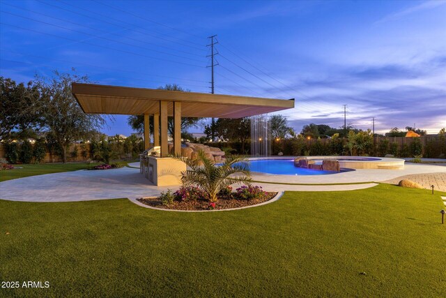 4547 S Banning Dr, Gilbert, AZ 85297 - pool at dusk featuring a patio area, a pool with connected hot tub, and a lawn