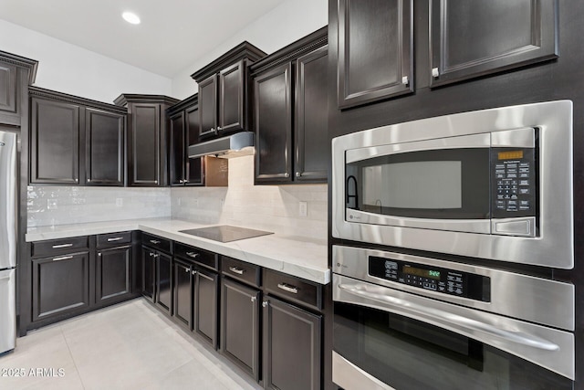 4547 S Banning Dr, Gilbert, AZ 85297 - kitchen with under cabinet range hood, light stone counters, backsplash, and stainless steel appliances