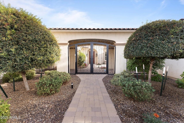 4547 S Banning Dr, Gilbert, AZ 85297 - property entrance with stucco siding, fence, a tile roof, and a gate