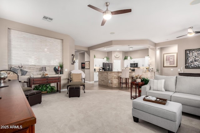 carpeted living room featuring ceiling fan