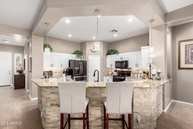 kitchen with white cabinets, kitchen peninsula, a breakfast bar area, and black appliances