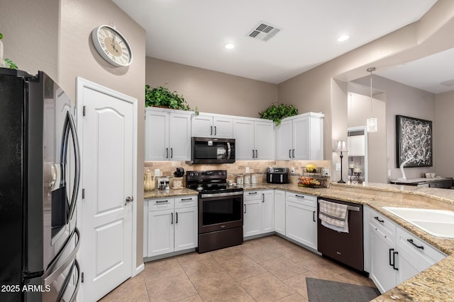 kitchen with pendant lighting, light stone counters, white cabinets, and appliances with stainless steel finishes