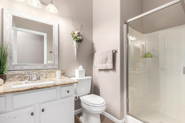 bathroom with vanity, toilet, and a shower with door