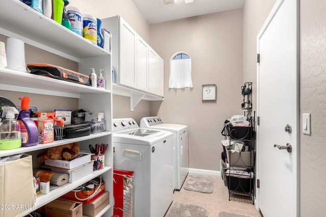 clothes washing area with cabinets, separate washer and dryer, and light tile patterned floors