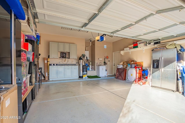 garage featuring a garage door opener and stainless steel fridge with ice dispenser