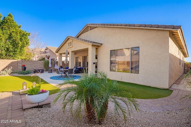 rear view of property with a yard and a patio