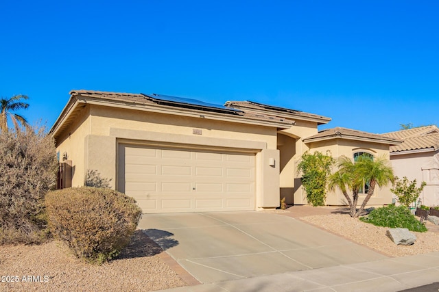 view of front of property featuring a garage and solar panels