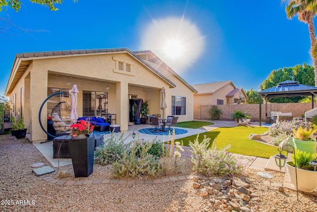 rear view of house featuring a gazebo, a yard, and a patio area