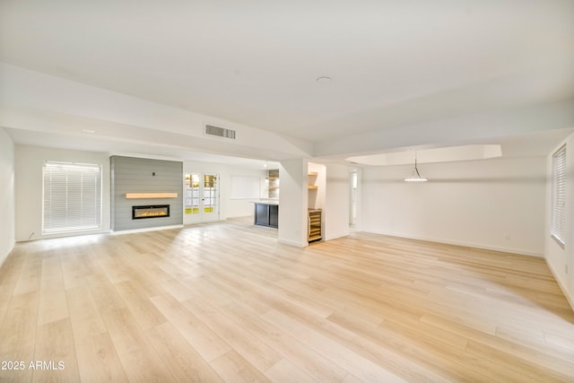 6739 E Thunderbird Rd, Scottsdale, AZ 85254 - unfurnished living room featuring baseboards, visible vents, light wood-style floors, and a fireplace
