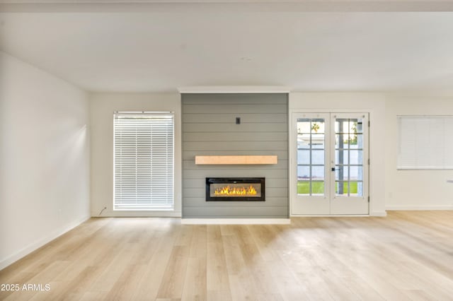 6739 E Thunderbird Rd, Scottsdale, AZ 85254 - unfurnished living room with a fireplace, french doors, light wood-type flooring, and baseboards