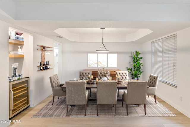 6739 E Thunderbird Rd, Scottsdale, AZ 85254 - dining area with beverage cooler, visible vents, light wood finished floors, and a tray ceiling