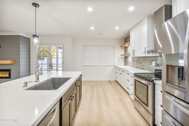 6739 E Thunderbird Rd, Scottsdale, AZ 85254 - kitchen featuring light wood finished floors, a sink, backsplash, baseboards, and appliances with stainless steel finishes