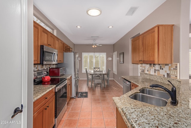 kitchen featuring sink, ceiling fan, light tile patterned floors, tasteful backsplash, and stainless steel appliances