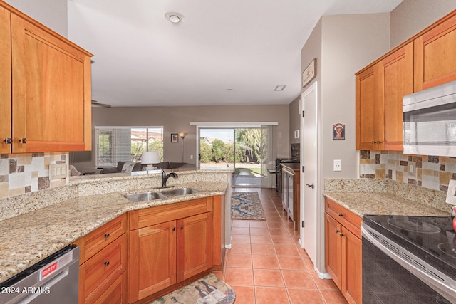 kitchen with appliances with stainless steel finishes, backsplash, light tile patterned floors, and sink