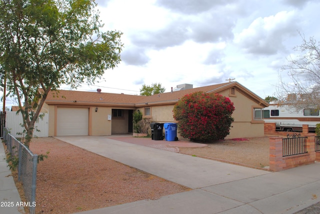 ranch-style house featuring stucco siding, an attached garage, and fence