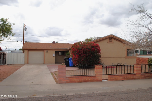 single story home with a fenced front yard, stucco siding, an attached garage, and concrete driveway