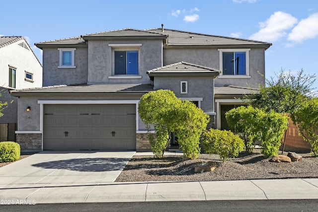 7180 W Tombstone Trl, Peoria, AZ 85383 - view of front of property featuring a tile roof, driveway, stucco siding, a garage, and stone siding