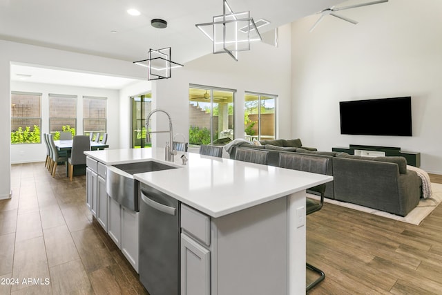 7180 W Tombstone Trl, Peoria, AZ 85383 - kitchen featuring a sink, stainless steel dishwasher, open floor plan, light countertops, and a kitchen island with sink