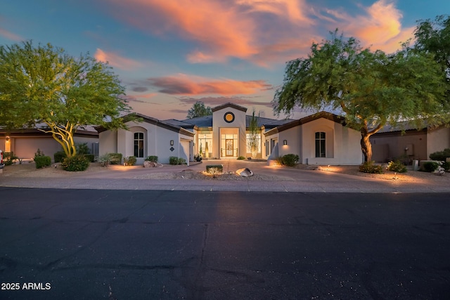 7775 E Fledgling Dr, Scottsdale, AZ 85255 - mediterranean / spanish-style home featuring an attached garage, stucco siding, and driveway