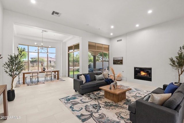 7775 E Fledgling Dr, Scottsdale, AZ 85255 - living area featuring recessed lighting, a glass covered fireplace, a chandelier, and a towering ceiling