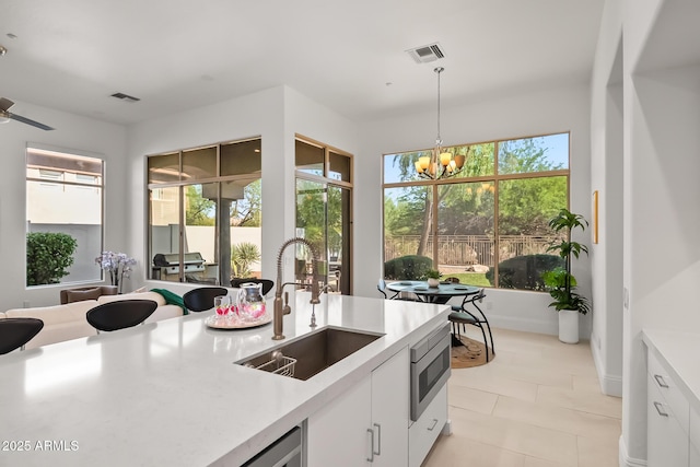 7775 E Fledgling Dr, Scottsdale, AZ 85255 - kitchen featuring white cabinetry, light countertops, a chandelier, decorative light fixtures, and light tile patterned floors