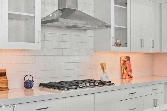 7775 E Fledgling Dr, Scottsdale, AZ 85255 - kitchen with island exhaust hood, stainless steel gas cooktop, white cabinets, and light countertops
