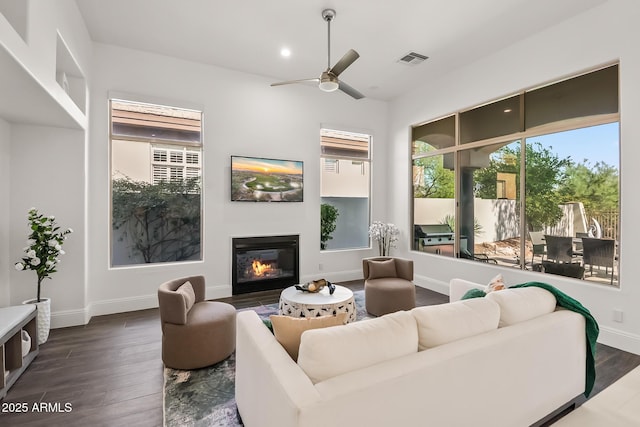 7775 E Fledgling Dr, Scottsdale, AZ 85255 - living room with dark wood-type flooring, a glass covered fireplace, ceiling fan, and recessed lighting