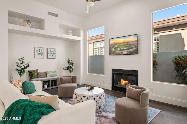 7775 E Fledgling Dr, Scottsdale, AZ 85255 - living room featuring a glass covered fireplace, wood finished floors, and ceiling fan