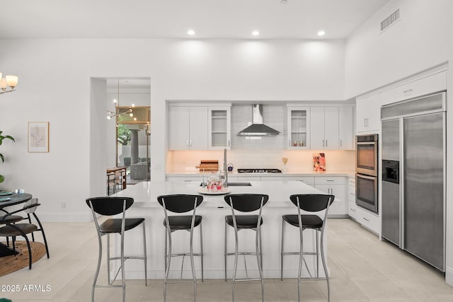 7775 E Fledgling Dr, Scottsdale, AZ 85255 - kitchen featuring built in refrigerator, wall chimney exhaust hood, double oven, light countertops, and backsplash