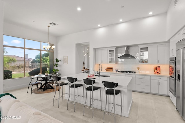 7775 E Fledgling Dr, Scottsdale, AZ 85255 - kitchen with wall chimney range hood, a chandelier, light countertops, decorative backsplash, and recessed lighting