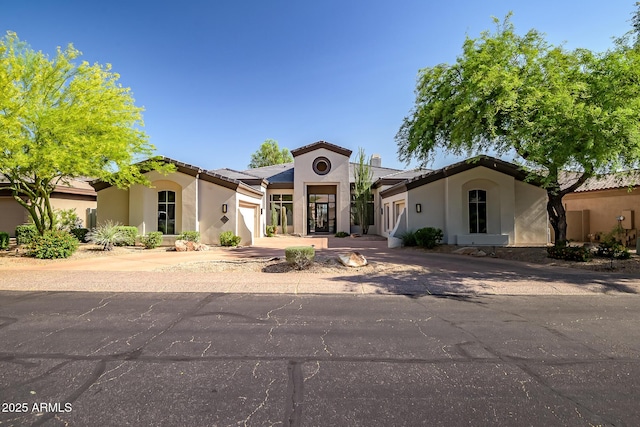 7775 E Fledgling Dr, Scottsdale, AZ 85255 - mediterranean / spanish-style house with an attached garage, stucco siding, and driveway