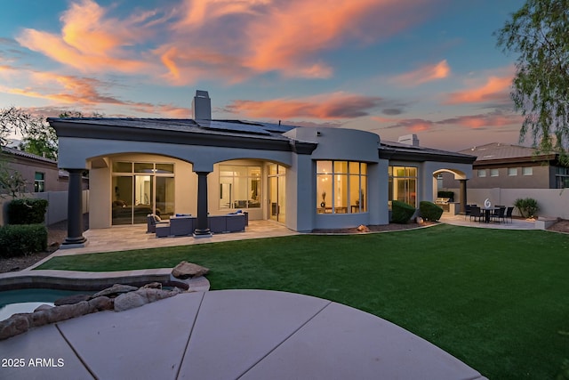 7775 E Fledgling Dr, Scottsdale, AZ 85255 - rear view of house with an outdoor hangout area, a chimney, a patio, a fenced backyard, and solar panels