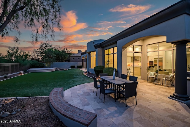 7775 E Fledgling Dr, Scottsdale, AZ 85255 - patio terrace at dusk featuring a patio, a fenced backyard, and a covered hot tub