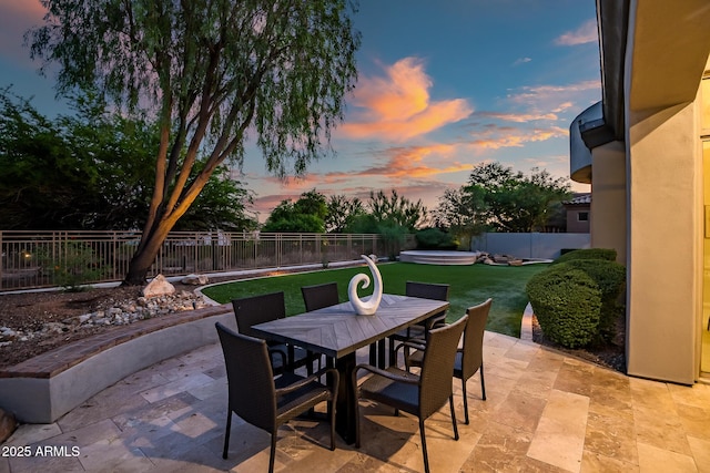 7775 E Fledgling Dr, Scottsdale, AZ 85255 - patio terrace at dusk featuring a patio, a fenced backyard, and outdoor dining space