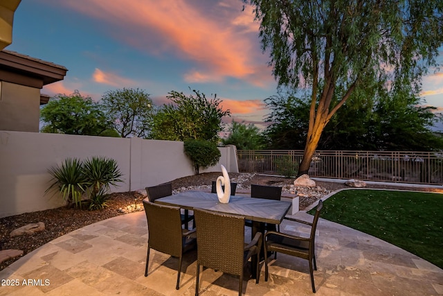 7775 E Fledgling Dr, Scottsdale, AZ 85255 - patio terrace at dusk with a patio, a fenced backyard, and outdoor dining area
