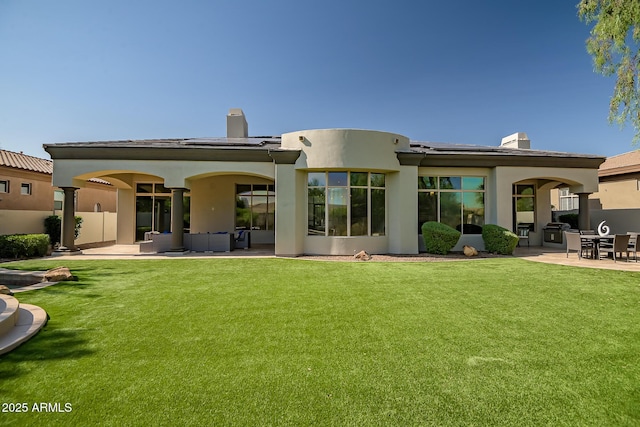 7775 E Fledgling Dr, Scottsdale, AZ 85255 - back of house featuring a patio, a chimney, solar panels, and a lawn