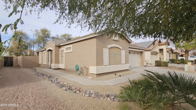 view of side of home with solar panels and a garage