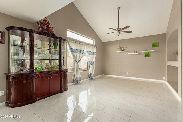 interior space featuring high vaulted ceiling, a ceiling fan, and baseboards