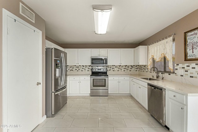 kitchen featuring visible vents, white cabinets, appliances with stainless steel finishes, light countertops, and a sink