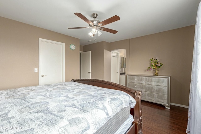 bedroom with arched walkways, dark wood-type flooring, a ceiling fan, and baseboards