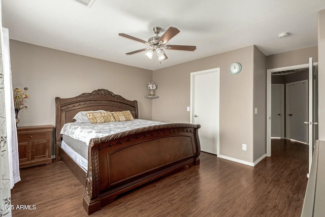 bedroom featuring dark wood-style floors, visible vents, baseboards, and a ceiling fan