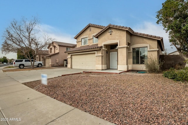 mediterranean / spanish house with a garage, concrete driveway, a tile roof, and stucco siding