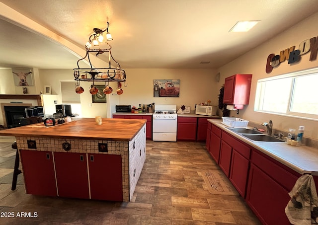 kitchen with butcher block countertops, sink, white appliances, a breakfast bar area, and a kitchen island