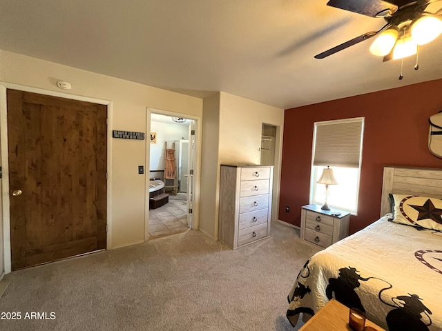 carpeted bedroom with ceiling fan and connected bathroom