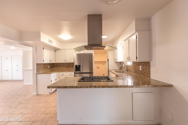 kitchen with sink, appliances with stainless steel finishes, white cabinetry, island exhaust hood, and kitchen peninsula