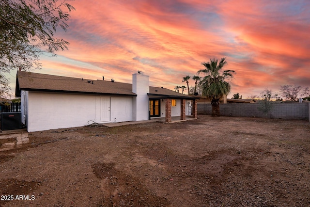 back house at dusk featuring central air condition unit